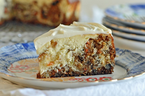 A slice of carrot cake cheesecake on a dessert plate.